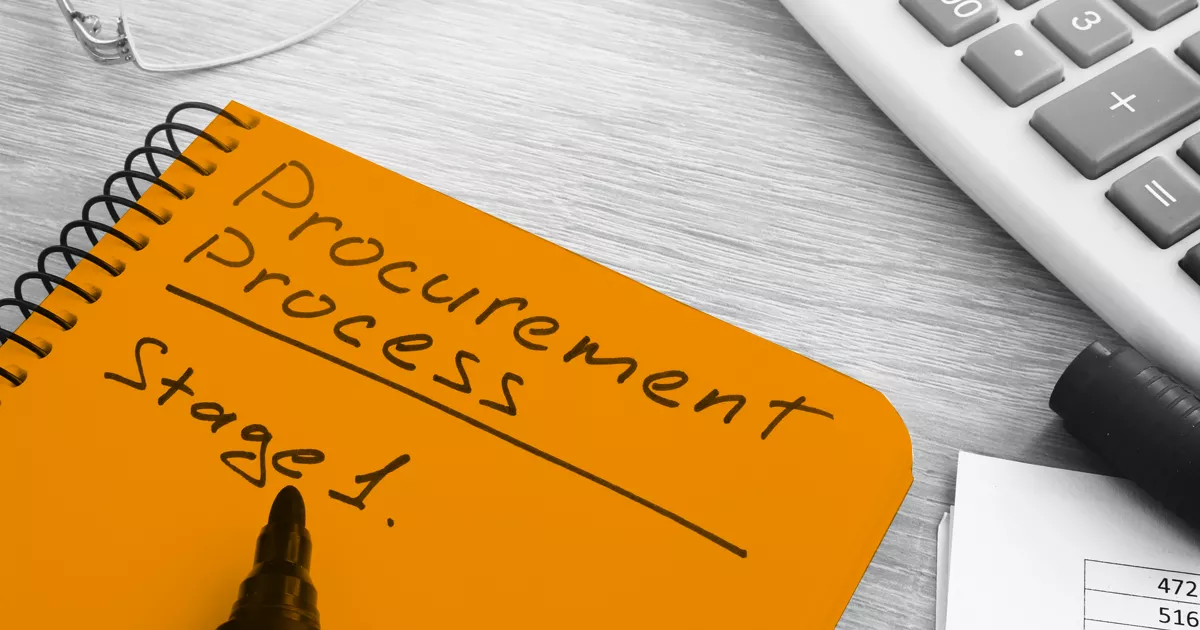 Image showing a orange highlighted notebook with the words procurement process stage 1 written on the cover
