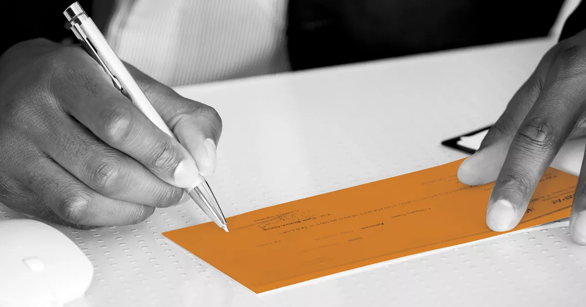 Image showing a person signing a check