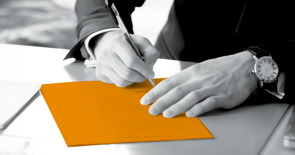 Image of a person in a suit signing a document