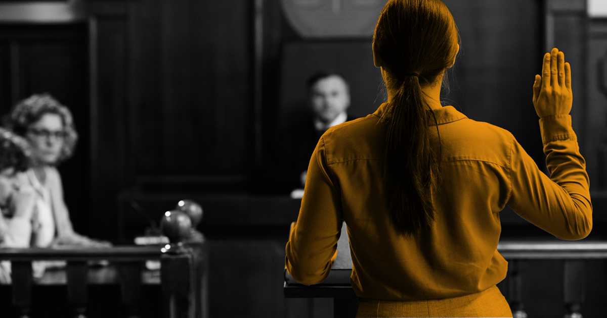 Image of a person standing in the court room being sworn in