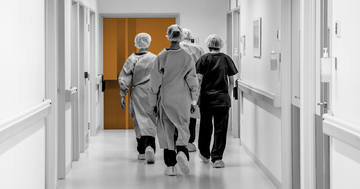Image showing a group of NHS employee's walking down a hosptal corridoor.