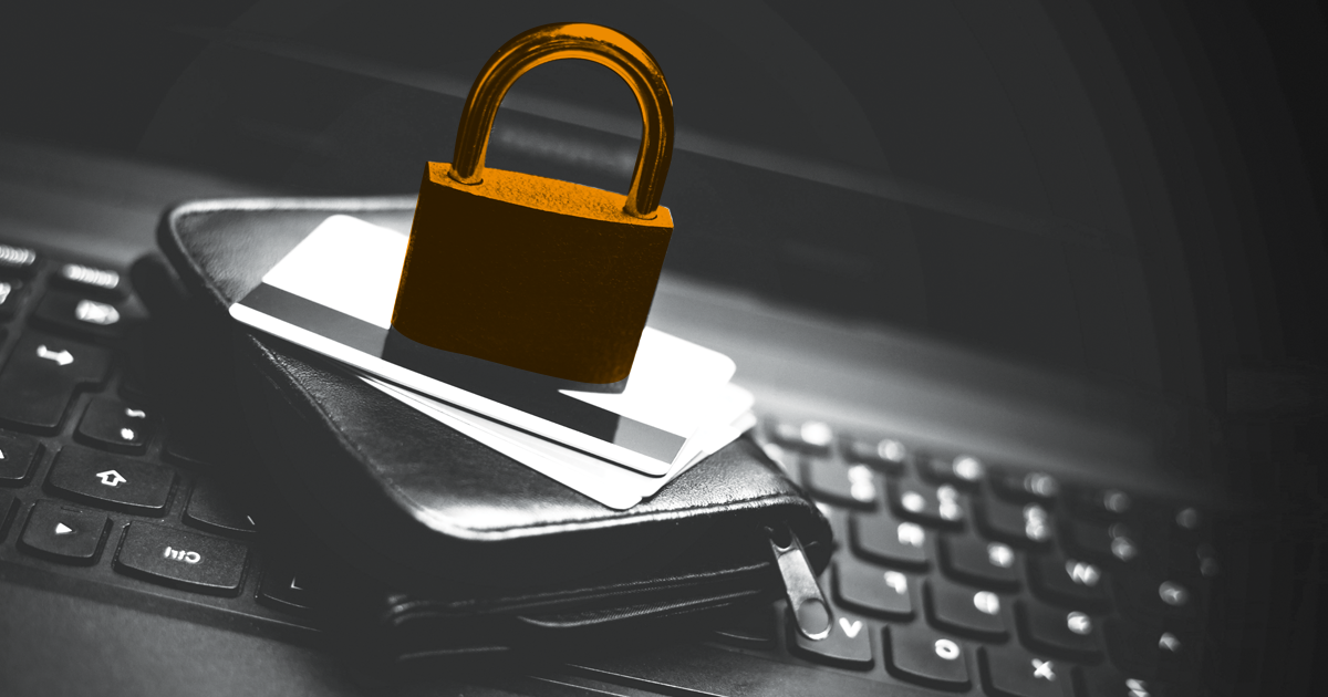 Image of a padlock ontop of cards stitting on top of a laptop.