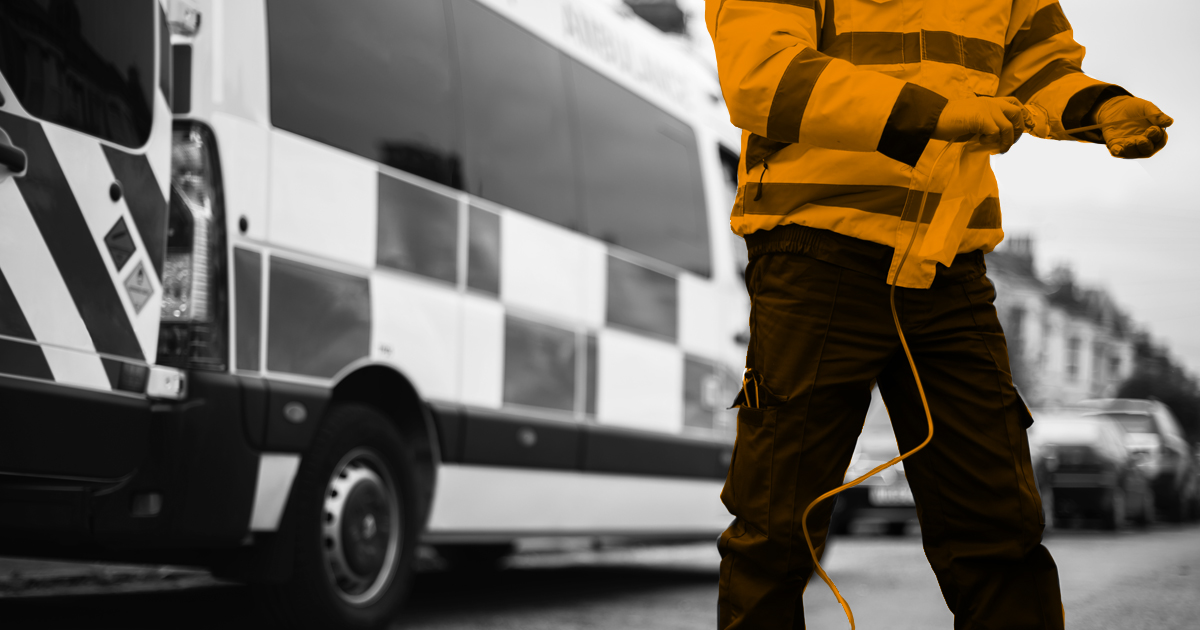 Image showing a faceless paramedic working infront of an ambulance