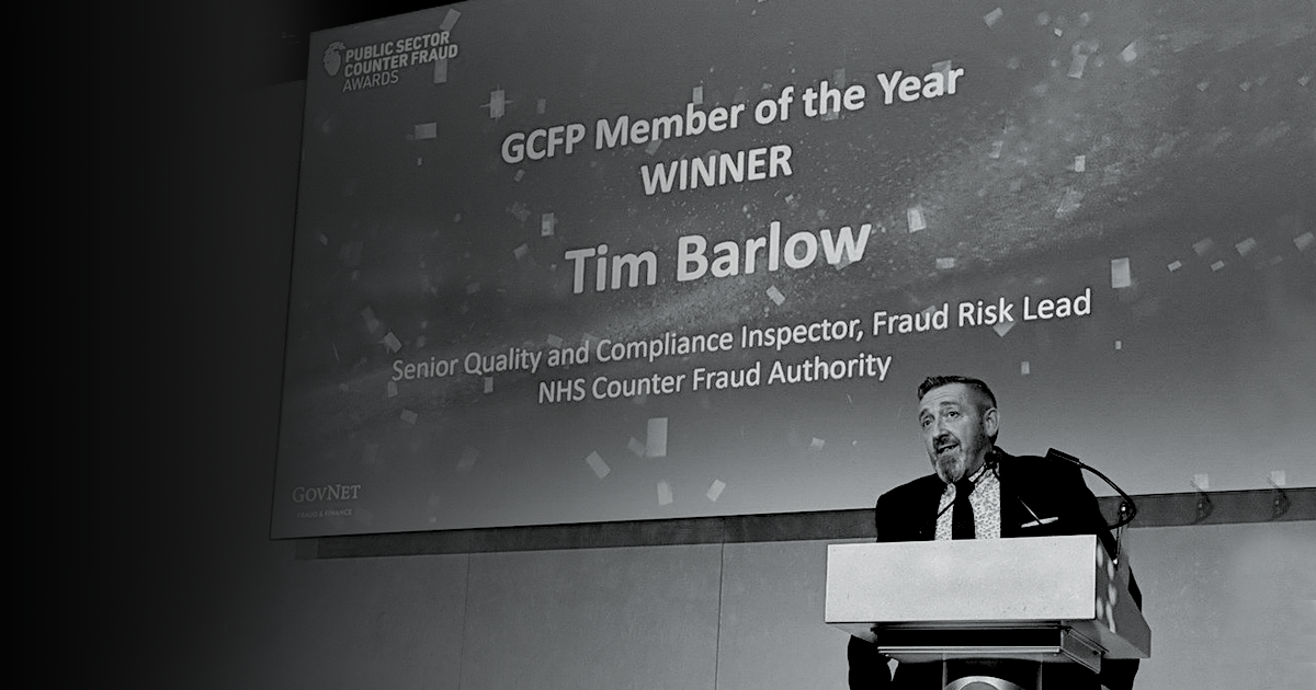Black and white image of Government Counter Fraud Professional (GCFP) Member of the Year award winner Tim Barlow presenting 