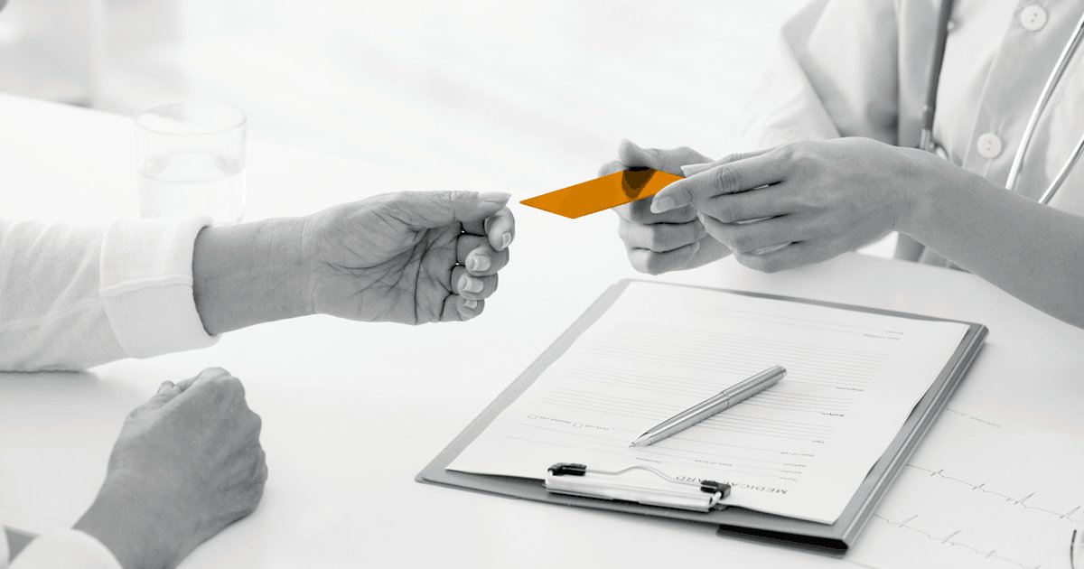 Image of medical person handing over a card to a medical profecional.