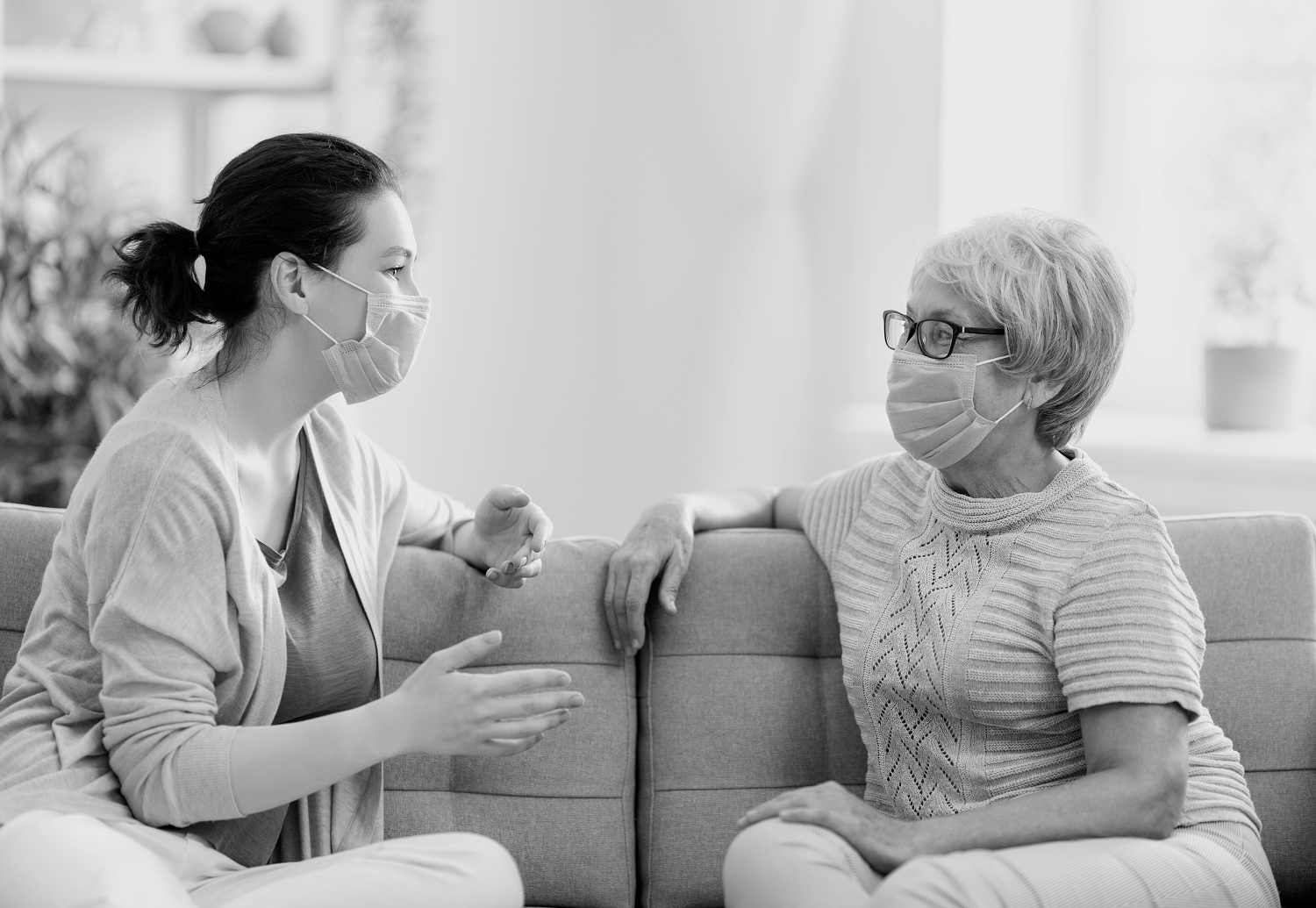 Image of two people wearing masks having a discussion.