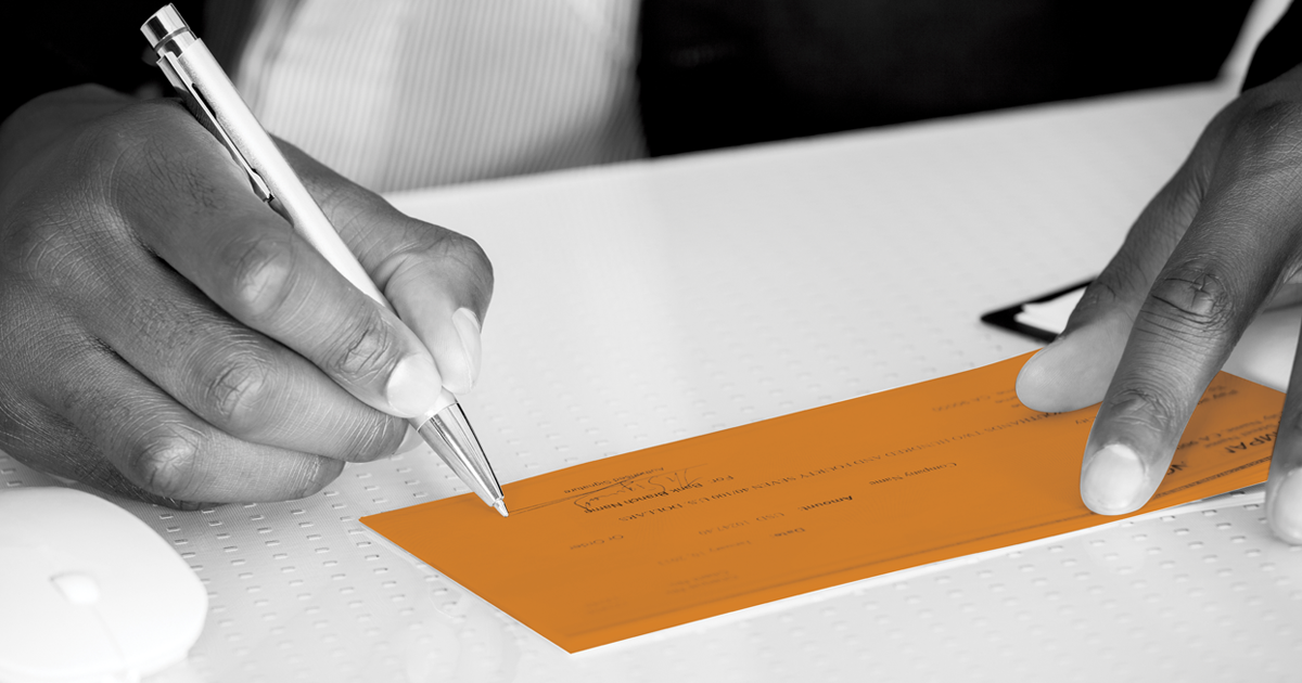 Image of cheque being signed.