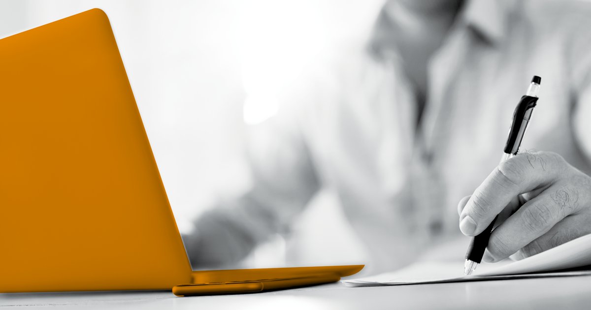 Image of a person siting at a laptop which is highlighted in orange