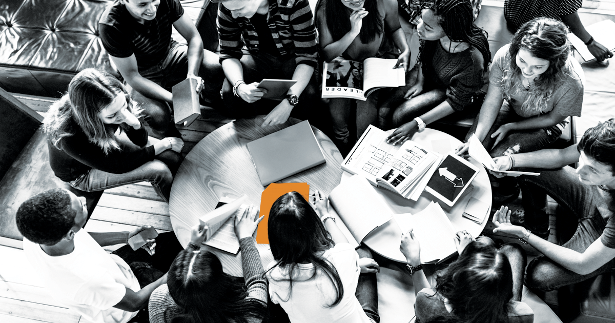 Image of a group of students studying with one document highlighted in oranges.